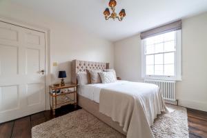 a white bedroom with a bed and a window at The New Cross Premier Rooms in London
