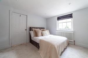 a white bedroom with a bed and a window at The New Cross Premier Rooms in London