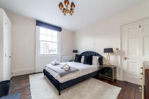 a bedroom with a large bed and a chandelier at The New Cross Premier Rooms in London