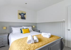 ein Schlafzimmer mit einem Bett mit Handtüchern darauf in der Unterkunft Postmans Cottage in Holt