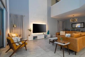sala de estar con sofá y TV en The Lovely Home Amazing 5BR, en Kissimmee