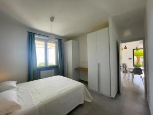um quarto com uma cama branca, uma mesa e cadeiras em Podere Belvedere em Moneglia