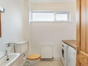 een witte badkamer met een toilet en een wastafel bij 4 Bed in The Cairngorms 46162 in Tomintoul