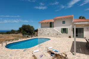 een villa met een zwembad en een huis bij Sarpedon - Forest Villas Crete, near the beach in Gállos