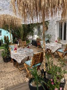 een patio met tafels en stoelen en een parasol bij The Corner Properties in Noirmoutier-en-l'lle