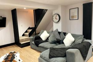 sala de estar con sofá y reloj en la pared en Cosy Cottage By MGroupSA, en Aberdare