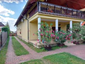 a house with a balcony and flowers on it at Hanol Apartmanház Balatonlelle in Balatonlelle