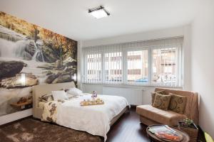 a bedroom with a bed and a couch at ZagrebRent Apartments in Zagreb