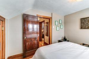 a bedroom with a bed and a wooden door at Quaint Howells Retreat - Steps from Main Street! 