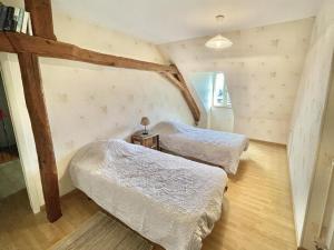 Habitación con 2 camas y vigas de madera. en Gîte Saint-Aubin-le-Monial, 4 pièces, 6 personnes - FR-1-489-490, en Saint-Aubin-le-Monial