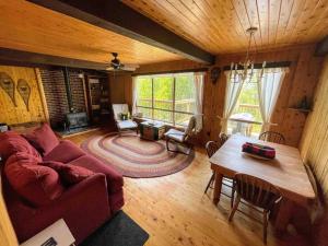 a living room with a red couch and a table at Blue Vista Tobermory Waterfront Cottage in Tobermory