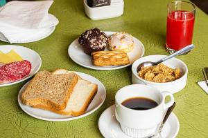 una mesa con platos de desayuno y una taza de café en Novapark, en Santiago