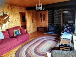 a living room with a pink couch and a stove at Blue Vista Tobermory Waterfront Cottage in Tobermory