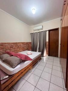 a bedroom with a bed and a brick wall at Made in Roça in Uberlândia