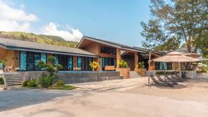 ein Haus mit einem Regenschirm und Stühlen davor in der Unterkunft Emon Pulo Beach Resort 