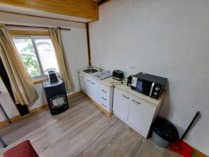 um quarto com uma cozinha com um micro-ondas e um balcão em Alojamiento Temuco em Temuco