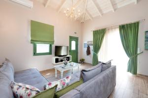 een woonkamer met een bank en een tafel bij Sarpedon - Forest Villas Crete, near the beach in Gállos