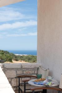 uma mesa com um prato de comida numa varanda em Sarpedon - Forest Villas Crete, near the beach em Gállos