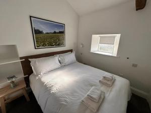 een slaapkamer met een bed met twee handdoeken erop bij Redmire Village Pub in Redmire