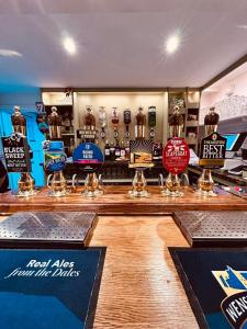 a bar with a counter with signs on it at Redmire Village Pub in Redmire