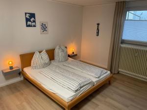 a bedroom with a bed with two lamps on it at Haus Baltic Koje 04 in Cuxhaven