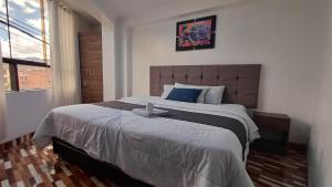 ein Schlafzimmer mit einem großen Bett und einem Fenster in der Unterkunft Qory Punku Villa Militar in Cusco