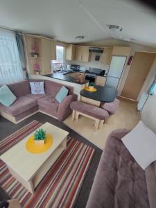 a living room with a couch and a table at M&C Caravan Hire Sunnysands in Barmouth
