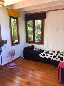 a room with a bed in a room with windows at La Tiny in Tigre