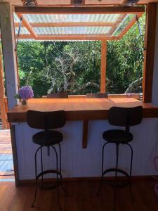 a bar with three stools in front of a window at La Tiny in Tigre