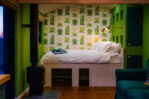 a bedroom with a bed in a room with green walls at Gooseberry Shepherds Hut in Worcester