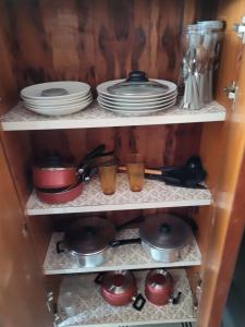 a cupboard with plates and pans and dishes at Apartamento Grande em Itapuã - Vila Velha in Vila Velha