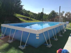 casa nel verde Cà dla cola في Mombasiglio: حمام سباحة كبير مع airmott