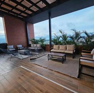 eine Terrasse mit Sofas, einem Tisch und Stühlen in der Unterkunft Apartamento zona 13 Aeropuerto Inara in Guatemala