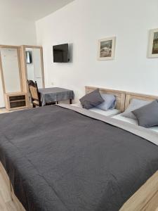 ein großes Bett mit einer schwarzen Decke drauf in der Unterkunft Ein Zimmer Wohnung am Markt in Oelsnitz