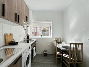 eine weiße Küche mit einem Waschbecken und einem Tisch in der Unterkunft Oasis Suite in Avila