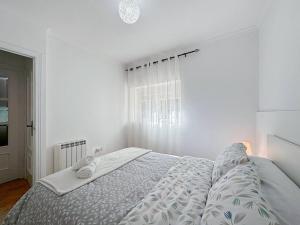 ein weißes Schlafzimmer mit einem Bett und einem Fenster in der Unterkunft Oasis Suite in Avila