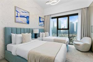 a hotel room with two beds and a window at Keysplease Beautiful 2BR Burj Khalifa View, Burj Royale Downtown in Dubai