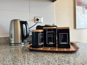 three coffee mugs on a wooden tray on a kitchen counter at Depto 1 Dormitorio 1504 Central con estacionamiento in Temuco