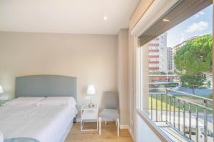 sypialnia z łóżkiem i dużym oknem w obiekcie Espacioso apartamento en el corazón de Pamplona w Pampelunie