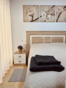 een slaapkamer met een bed met een zwarte deken bij Piso nuevo muy cerca de la playa in Santa Pola
