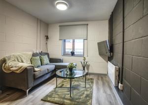 シェフィールドにある#71 Phoenix Court By DerBnB, Industrial Chic 1 Bedroom Apartment, Wi-Fi, Netflix & Within Walking Distance Of The City Centreのリビングルーム(ソファ、テーブル付)