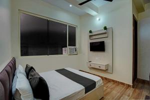 a bedroom with a bed and a large window at OYO Hotel AXN RESORT in Panchli