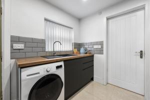 a kitchen with a washing machine and a sink at Modern Cozy 1 Bedroom Flat in Prime Location in Moseley in Birmingham