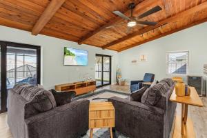 uma sala de estar com 2 sofás e uma ventoinha de tecto em Anchors Away - Pool with Spa - Garage Game Room em Cape Coral