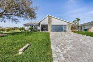 uma casa com uma entrada de tijolos em frente a uma casa em Anchors Away - Pool with Spa - Garage Game Room em Cape Coral