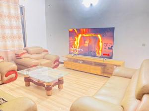 sala de estar con sofás y TV de pantalla plana. en Christina Residence, en Dar es Salaam