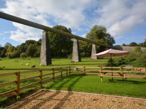 een hek met een paraplu en een veld met schapen bij 2 Bed in Bristol 72582 in Winford