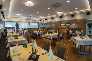jadalnia z białymi stołami i krzesłami oraz restauracja w obiekcie Penker Wirt Zimmer BANK w mieście Penk