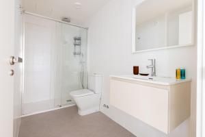 a white bathroom with a toilet and a shower at Exclusivo Dúplex en Salamanca in Madrid