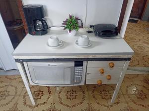 um balcão de cozinha com um micro-ondas e comodidades para preparar café em Refugio Piratininga 201 em Niterói
